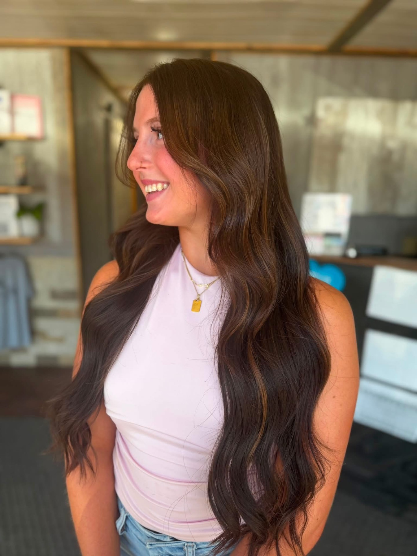 Long brunette waves with soft dimension, styled at Premiere Hair & Co.